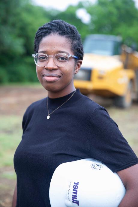 Michaela 柯克 standing in front of a construction vehicle